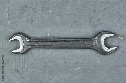 wrench on a gray painted wood surface. metal tools for manual work