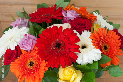 Bright bouquet of daisies, roses and green branches. close up