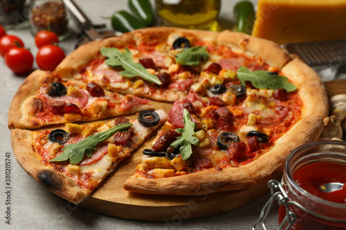 Tasty pizza and ingredients on gray background