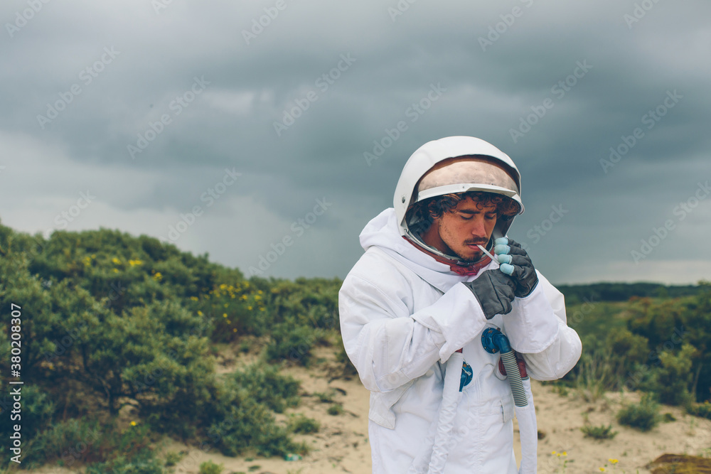 Man in spacesuit lighting up a cigarette. Man in spacesuit lighting up a cigarette.
