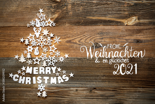 White Little Christmas Decoration Items Building Christmas Tree. German Frohe Weihnachten Und Ein Glueckliches 2021 Means Merry Christmas And A Happy 2021. Brown Rustic Wooden Background