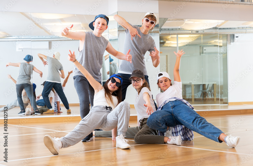Group of dancing teenagers posing in dance studio. Hip hop dancers