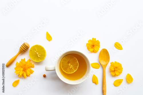 herbal healthy drinks hot honey lemon health care for cough sore with lemon slice ,yellow flowers cosmos of lifestyle arrangement flat lay style on background white 