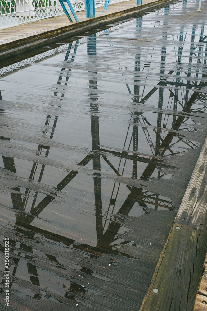 Framework of a bridge reflected in water puddles Framework of a bridge reflected in water puddles