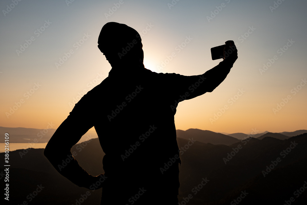 silhouette of a person taking his own picture against the magnificent view