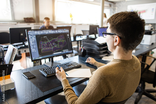 Engineer designer working on desktop computer in factory photo