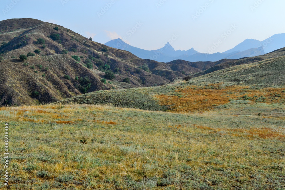 Panoramic view of blue height mountain range peaks. Beautiful Crimea landscape. Hills with dry yellow green grass. Summer