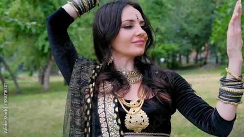 Portrait of a female model in ethnic indian costume with  jewellery and traditional makeup.  Woman in indian clothes dancing belly dance. Young beautiful woman in national costume dancing tribal dance