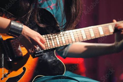 A lady playing guitar indoor photo