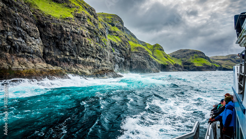Canvas Print Blurred tourists observe the spectacular Vestmanna cliffs in Faroe Islands