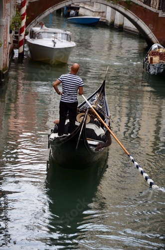 Gondolier in a gondola on a channel in Venice, Italy, a sunny day in autumn © ClaudiaRMImages