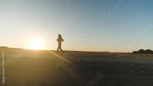 running after sun. Young Asian women are exercising with outdoor running with mountain background. When sun sets in Thailand in summer, Concept healthy running and outdoor exercise,Tracking dolly shot