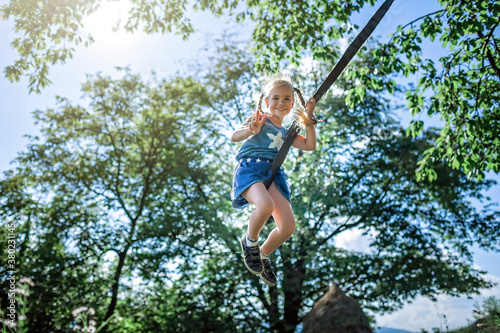 Real happy summertime. Girl flying on a swing in the mountains far from people, outdoor