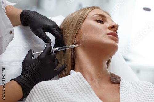 Biorevitalization procedure. Beautician making injection in woman's face