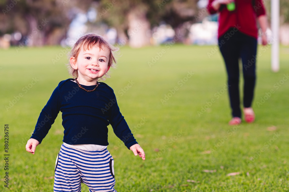 Toddler running and playing in a park Toddler running and playing in a park