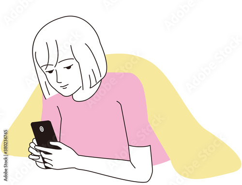 スマートフォンをうつ伏せで見つめる女性