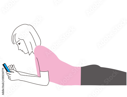 スマートフォンをうつ伏せで見つめる女性