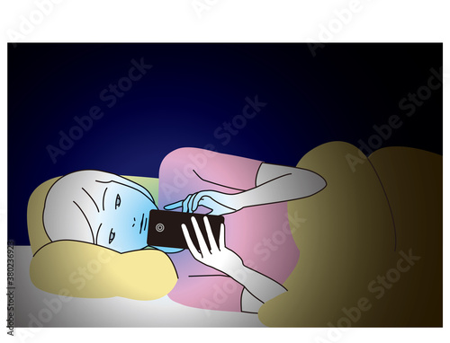 スマートフォンをベッドの中で見つめる女性