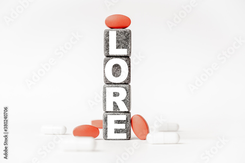 a group of white and red pills and cubes with the word LORE on them, white background. Concept carehealth, treatment, therapy. photo