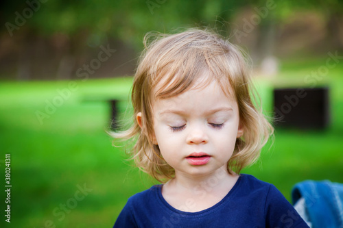 portrait of a cute little girl with closed eyes