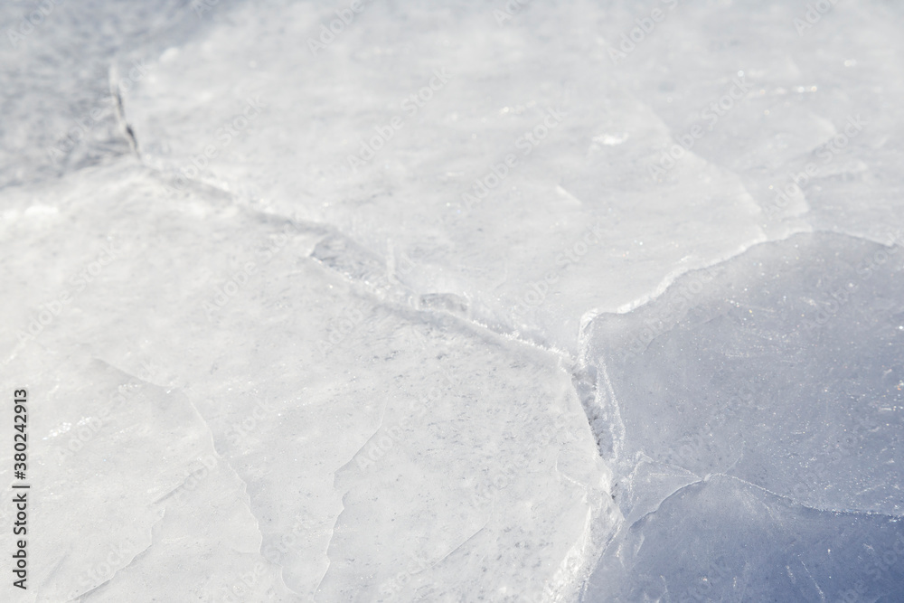 Close-up of cracked ice on a frozen lake in the winter, viewed from the front. Abstract textured full frame background. Copy space. Close-up of cracked ice on a frozen lake in the winter, viewed from the front. Abstract textured full frame background. Copy space.