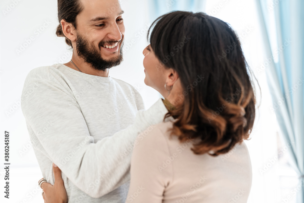 Image of romantic joyful couple smiling and hugging while standing Image of romantic joyful couple smiling and hugging while standing