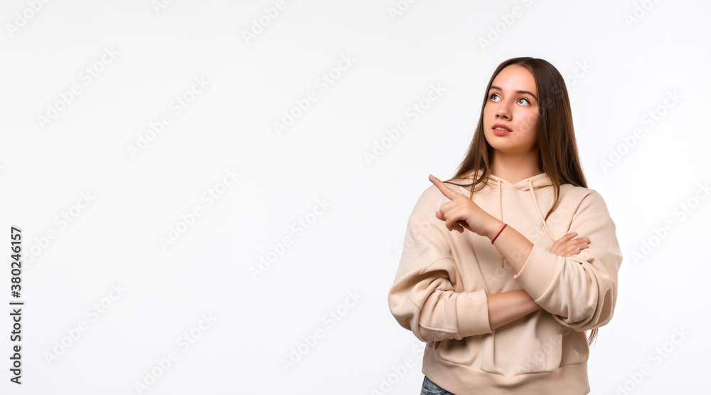 Happy Pretty young woman with long chestnut hair, pointing finger to the side, shows copy space for your information Happy Pretty young woman with long chestnut hair, pointing finger to the side, shows copy space for your information