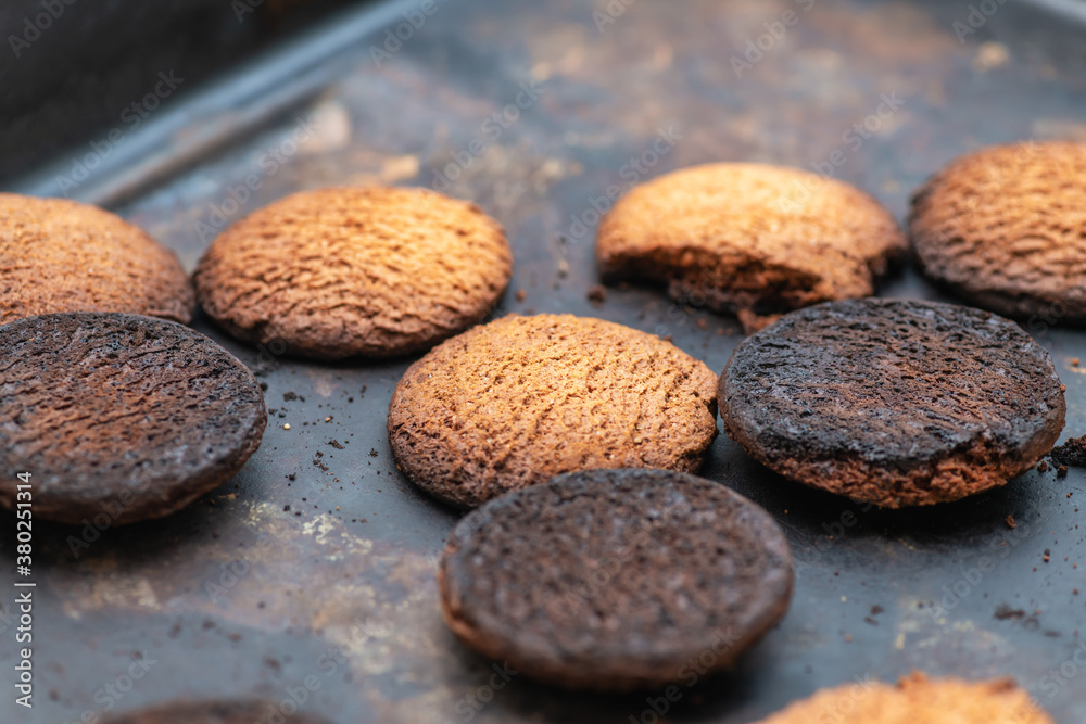 Burnt cookies. Burnt, burnt oatmeal cookies lie on a black baking sheet. Burnt cookies. Burnt, burnt oatmeal cookies lie on a black baking sheet.