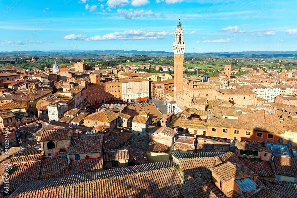 Aerial panorama of Siena, a beautiful medieval town in Tuscany Italy, with the famous landmark Mangia Tower ( Torre del Mangia ) standing tall by town square ( Piazza del Campo ) in city center