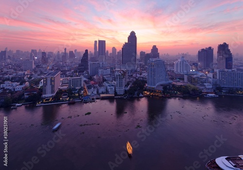 Aerial panorama of Bangkok City in morning twilight  with rosy clouds in the sky  boats   ships on Chao Phraya River   modern skyscrapers by the riverside Sunrise scenery of Bangkok in bird s eye view