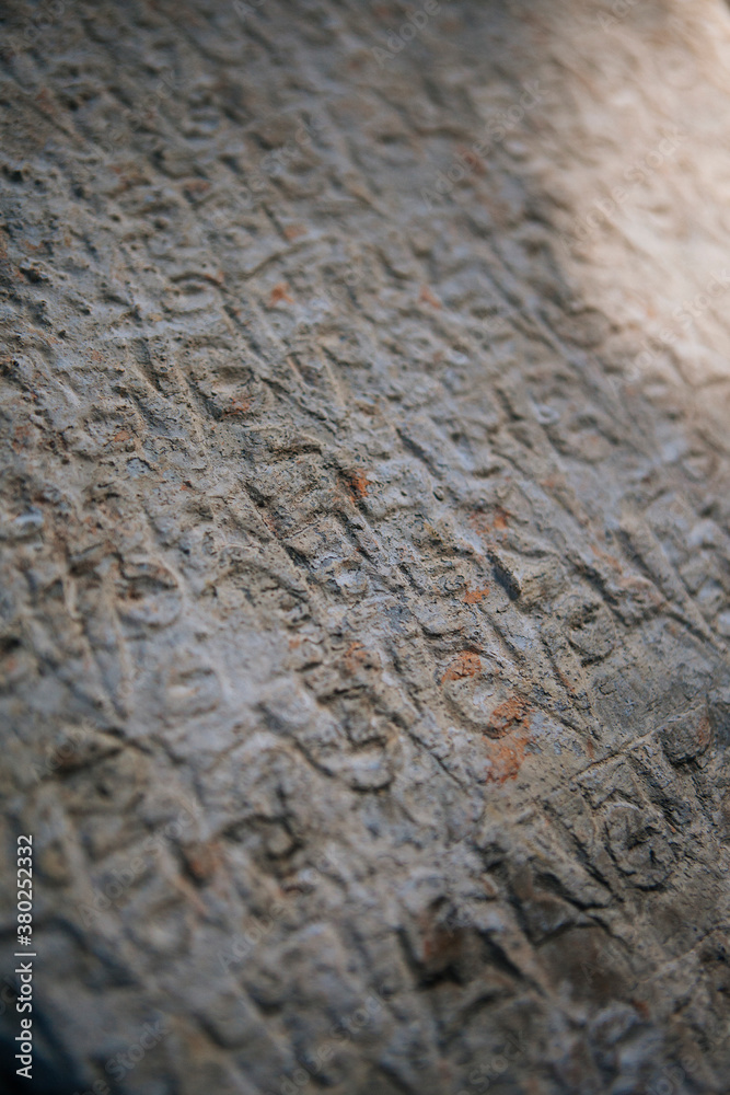 Stones with details of ancient buddhist manuscript near a monastery, Nepal. Stones with details of ancient buddhist manuscript near a monastery, Nepal.