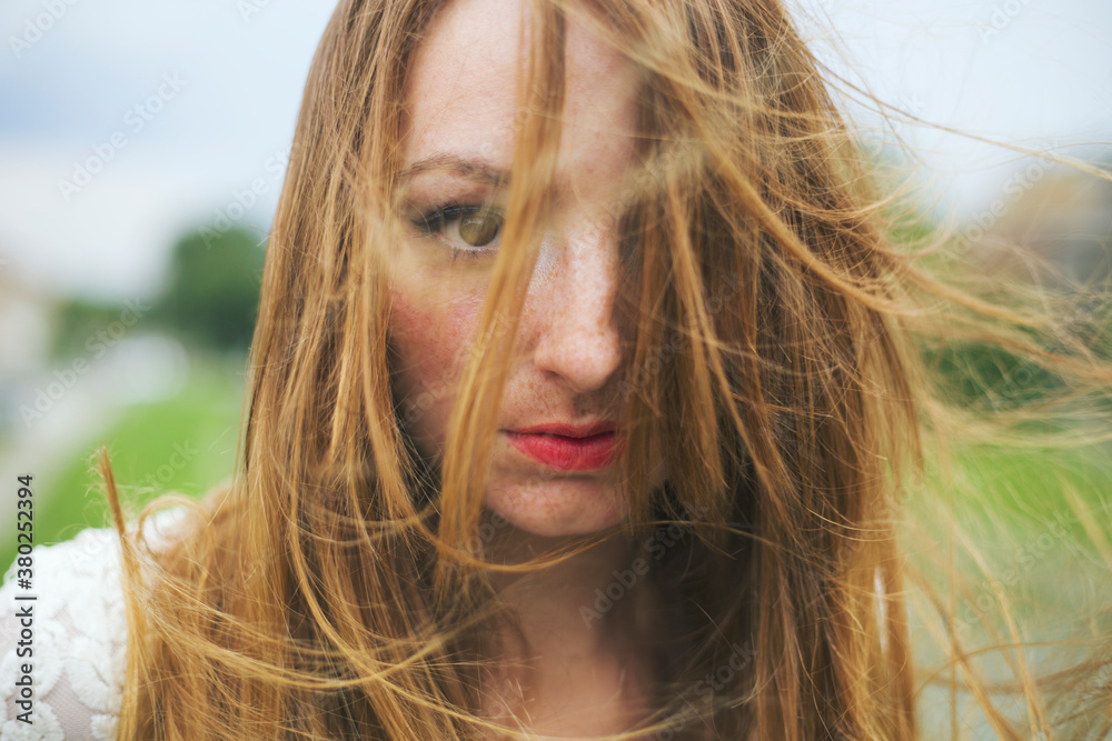 Portrait of a beautiful young woman with hair blown by wind Portrait of a beautiful young woman with hair blown by wind