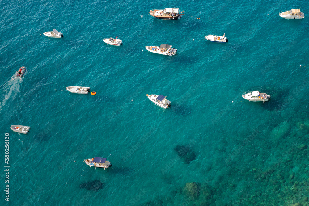 Aerial view of a group of small boats anchored near a small cove in the Gulf of Naples near Positano, Italy