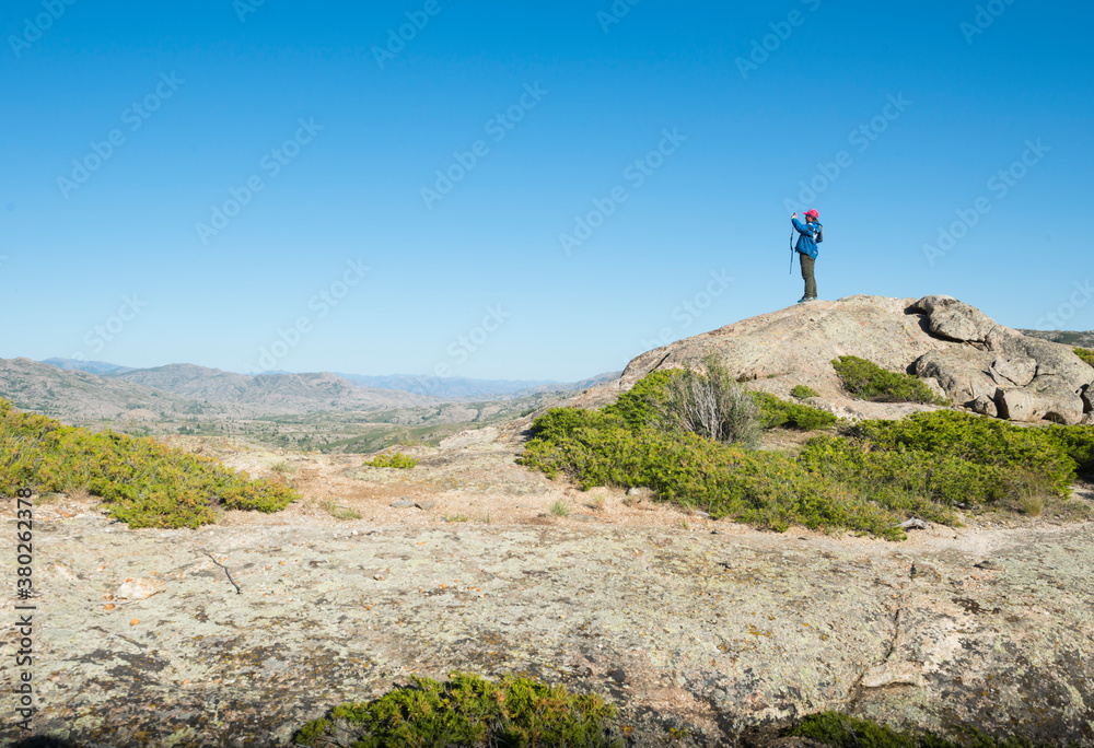 Man taking photo on rock of highland in Shinjang China