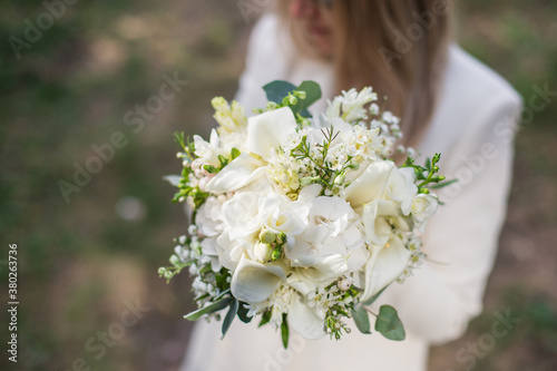 Wedding bouquet in bride hands. Roses, eustoma, eucalyptus in elegant bouquet. Summer and autumn flowers. photo