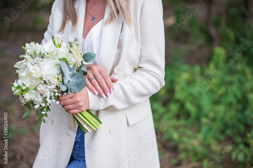 Wedding bouquet in bride hands. Roses, eustoma, eucalyptus in elegant bouquet. Summer and autumn flowers. photo