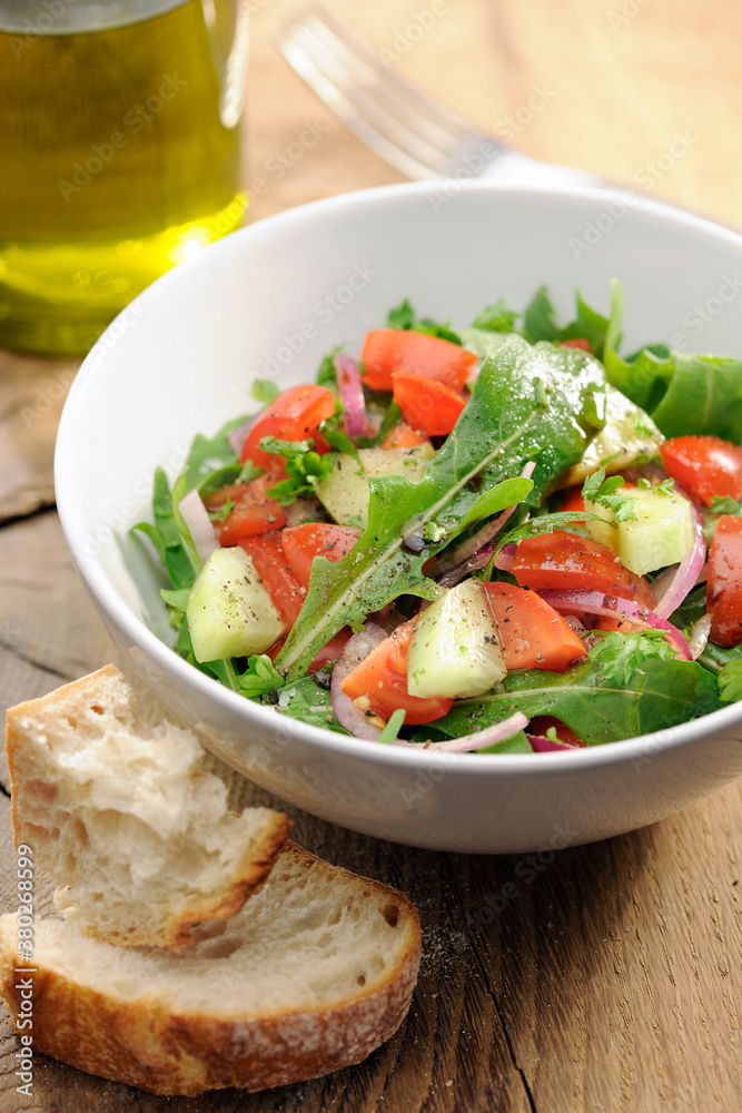 Food: Fresh salad with arugula, rocket, tomato and cucumber Food: Fresh salad with arugula, rocket, tomato and cucumber