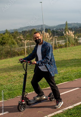 man with mask starts the march on electric scooter