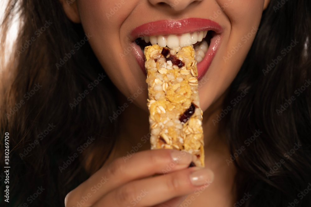 closeup of  woman eating cereal bar