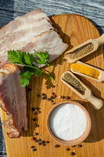 Still life with pieces of bacon on the wooden background