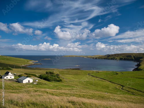 The bay of Otterswick on the east coast of the island of Yell in Shetland, UK, taken on a calm, sunny day with light cloud in summer.