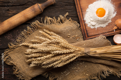 Bread baking bakery concept. Eggs, flour, spikelets on a wooden antique table.top view photo