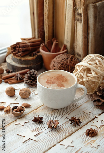 Cup of coffee, cinnamon, nuts on wooden table. atmosphere cozy fall or winter season concept.