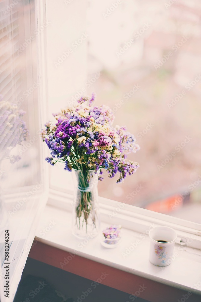 Beautiful flowers in a vase and coffee on a window Beautiful flowers in a vase and coffee on a window