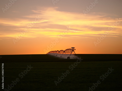 Tableau sur toile Center pivot irrigation system in the farm field at sunset