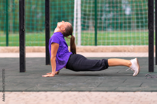 Young athletic woman practicing yoga outdoors © kolotype