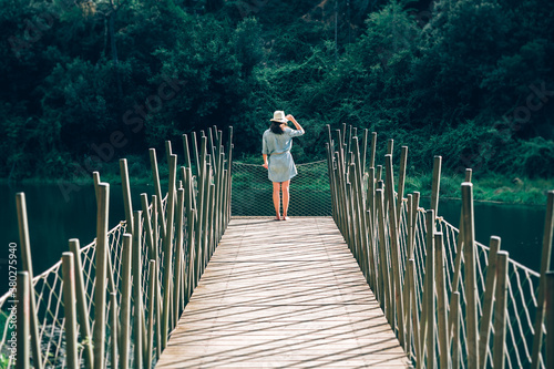 Woman with a hat standing at the end of a pontoon photo