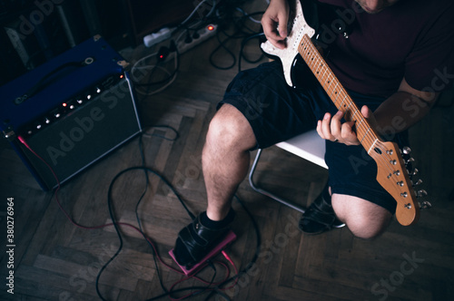 Guy playing on eletric guitar with amp
