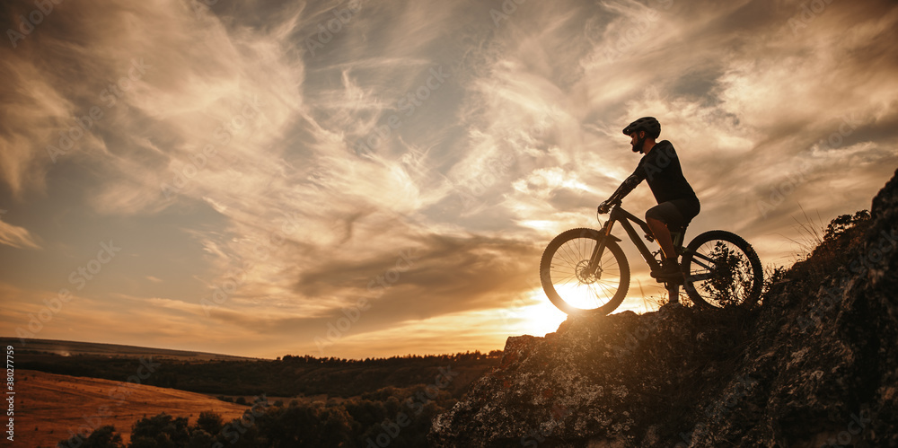 Man on mountain bike against sundown sky - obrazy, fototapety, plakaty 