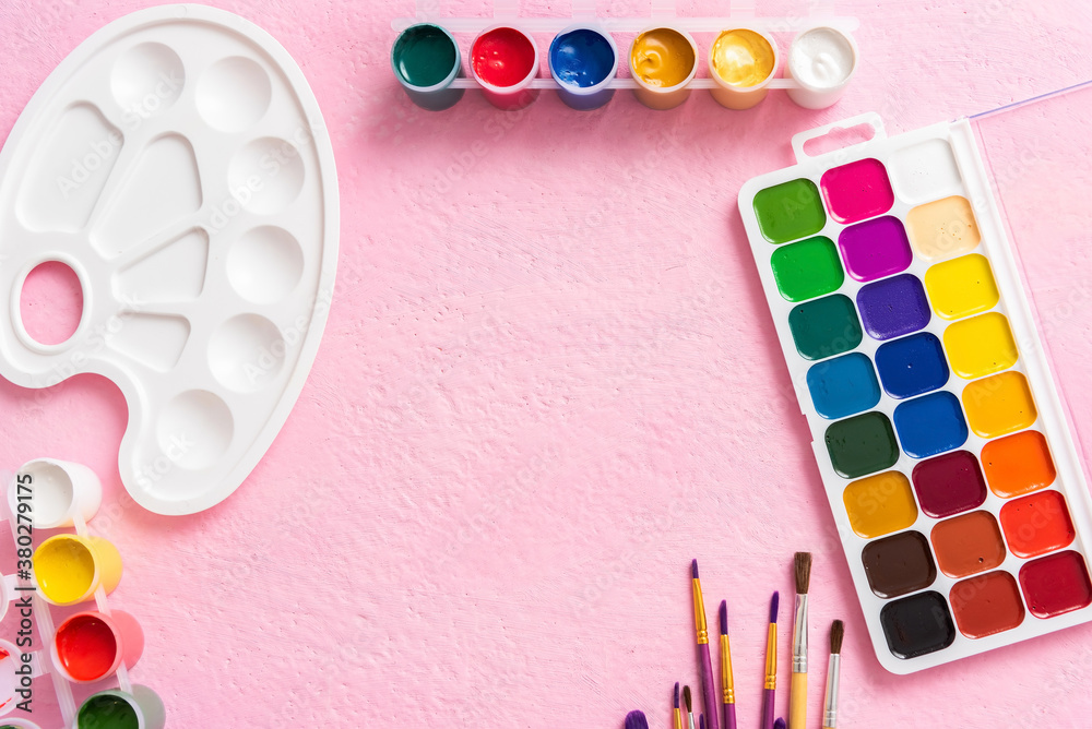 Brushes with paints on a pink background. Copy space. Brushes with paints on a pink background. Copy space.